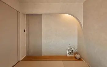 淡い色の塗り壁とアーチ状のニッチが特徴の和室スペース