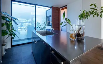 スタイリッシュなステンレスキッチンとガラス戸のある空間