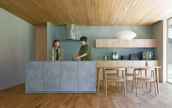 大きな窓とガラス扉で自然光がたっぷり入るテレビルーム。フローリングにビーズクッションが置かれたミニマルなインテリア。