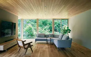 木目調のキッチンとダイニングテーブルが配置された温かみのある空間。白いペンダントライトが優しく照らす北欧風デザイン。